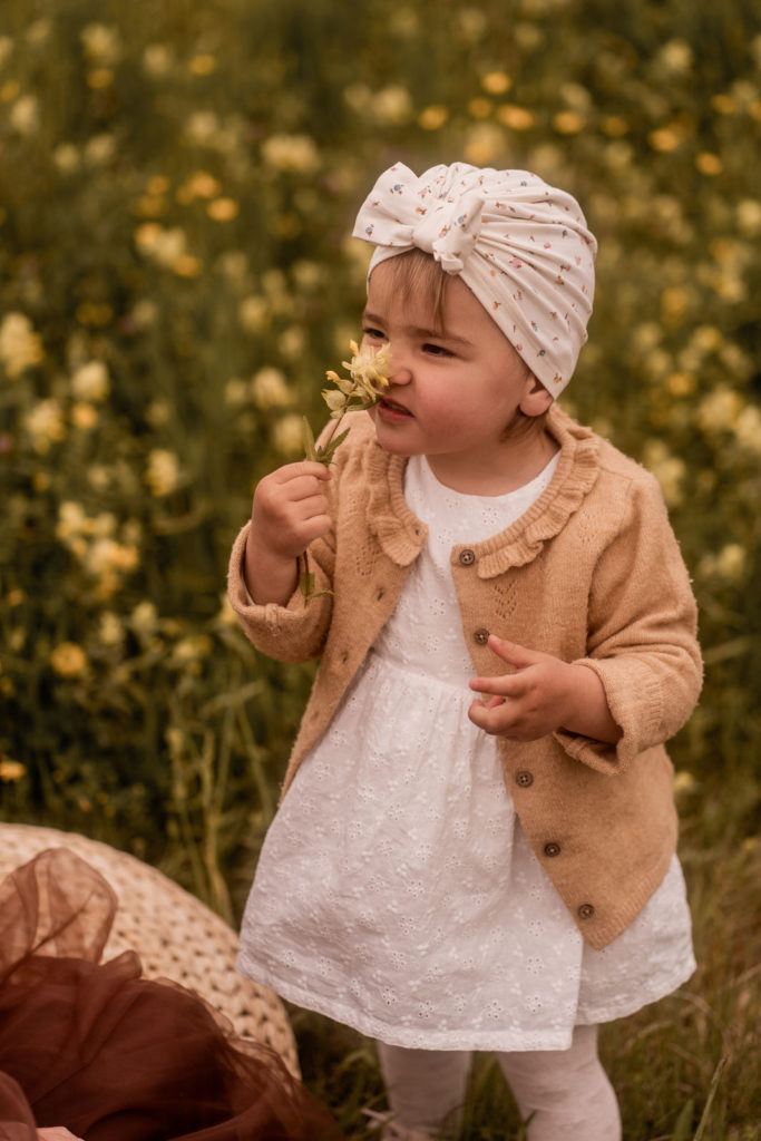 Kleines Mädchen riecht an einer Blume bei einem Mummy-and-me-Shooting von PIC@MO mit Mona von Malm